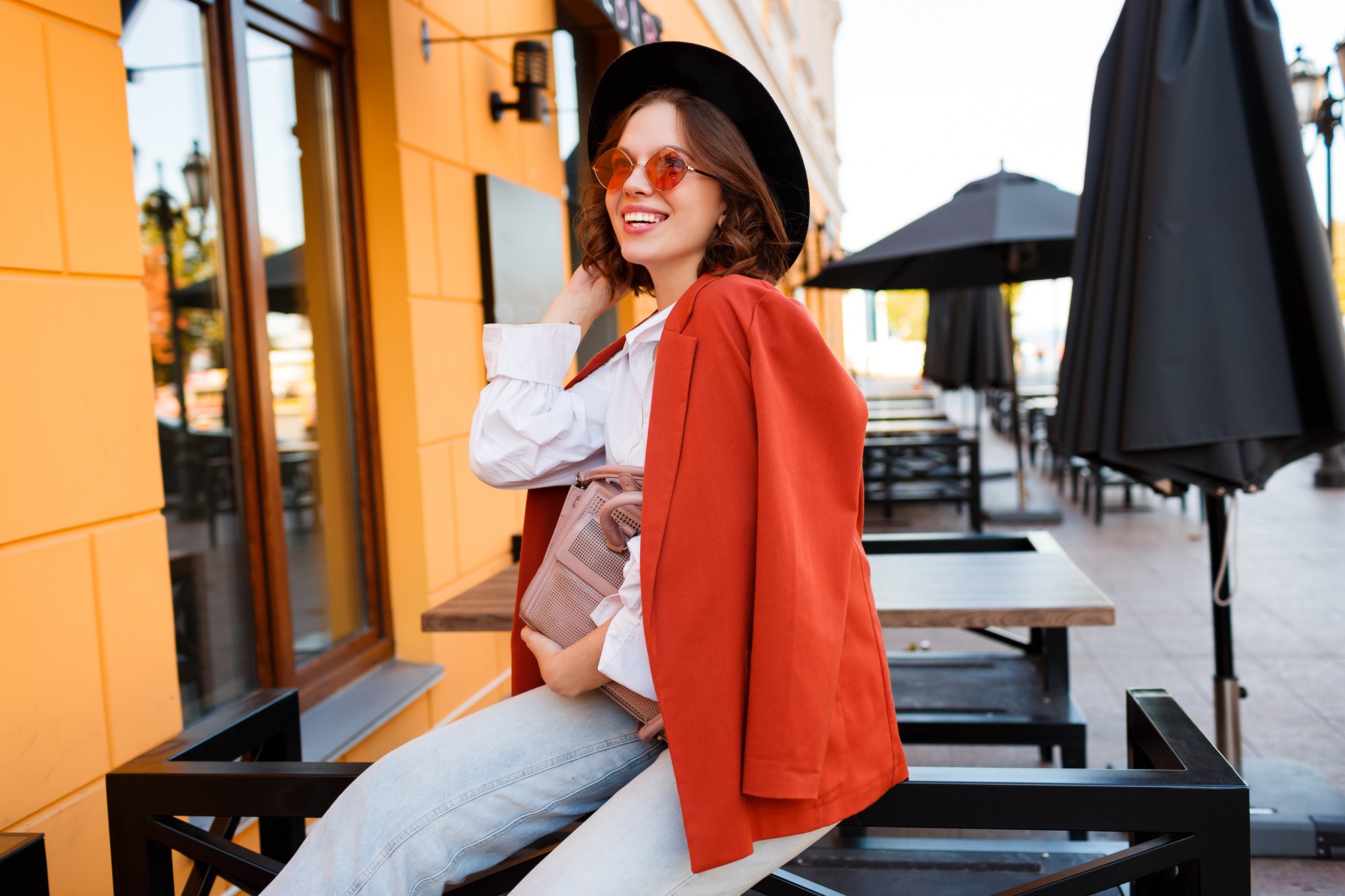 Smiling European girl in jacket and black hat.
