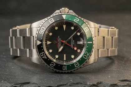 Rolex GMT-Master II 126710GRNR avec lunette céramique noire et verte posée sur une surface en ardoise sombre, vue macro détaillée du cadran et du bracelet Oystersteel